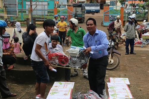 Trưởng Dân tộc huyện Điểu Kiêng (áo xanh) giao máy móc, nông cụ cho bà con.