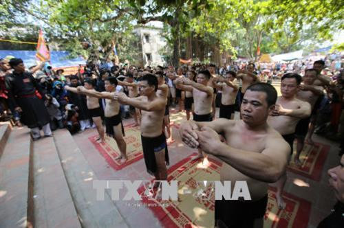 16 trai tráng khỏe mạnh, có phẩm chất, đạo đức để tham gia vật cầu, được gọi là quân cầu, làm lễ tại đình làng trước giờ thi đấu. Ảnh: Tùng Lâm – TTXVN