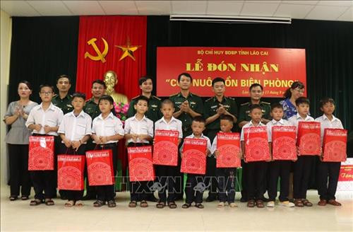 Tặng quà cho các cháu được các Đồn biên phòng ở Lào Cai nhận nuôi dưỡng tại đồn. Ảnh: Quốc Khánh - TTXVN Tặng quà cho các cháu được các Đồn biên phòng ở Lào Cai nhận nuôi dưỡng tại đồn. Ảnh: Quốc Khánh - TTXVN