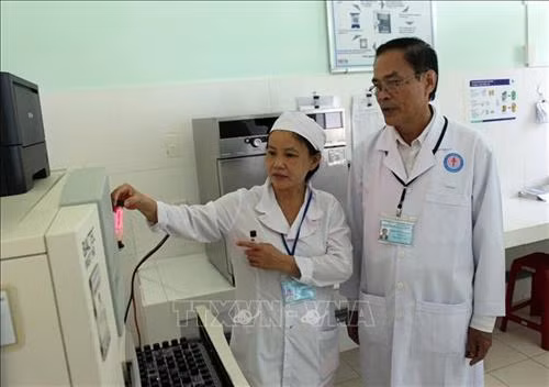 Bác sĩ Trần Ngọc Pháp (bên phải) là người đi tiên phong trong việc áp dụng những phương pháp mới trong điều trị bệnh lao ở Bệnh viện Phạm Ngọc Thạch (tỉnh Quảng Nam). Ảnh: Đỗ Trưởng - TTXVN