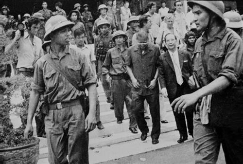 Hình ảnh Quân giải phóng dẫn giải Tổng thống Dương Văn Minh và Thủ tướng Vũ Văn Mẫu của Ngụy quyền Sài Gòn tới Đài Phát thanh để đọc lời tuyên bố đầu hàng vô điều kiện, trưa 30/4/1975, đánh dấu thắng lợi trọn vẹn của chiến dịch Hồ Chí Minh lịch sử, được phóng viên TTXVN ghi lại. Ảnh: TTXVN Hình ảnh Quân giải phóng dẫn giải Tổng thống Dương Văn Minh và Thủ tướng Vũ Văn Mẫu của Ngụy quyền Sài Gòn tới Đài Phát thanh để đọc lời tuyên bố đầu hàng vô điều kiện, trưa 30/4/1975, đánh dấu thắng lợi trọn vẹn của chiến dịch Hồ Chí Minh lịch sử, được phóng viên TTXVN ghi lại. Ảnh: TTXVN