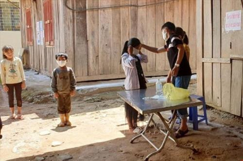 Giáo viên Trường Tiểu học xã Tá Pạ, huyện Mường Tè (Lai Châu) hướng dẫn học sinh rửa tay sát khuẩn và đeo khẩu trang. Ảnh: Việt Hoàng - TTXVN