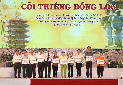 Thủ tướng Nguyễn Xuân Phúc trao sổ tiết kiệm cho thân nhân 10 nữ liệt sĩ Thanh niên xung phong Ngã ba Đồng Lộc. Ảnh: Thống Nhất-TTXVN