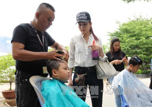 Cắt tóc miễn phí cho các thiếu nhi tại công viên Khánh Hội, quận 4. Ảnh: An Hiếu - TTXVN