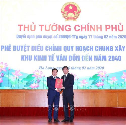 Thứ trưởng Bộ Xây dựng Nguyễn Tường Văn trao Quyết định phê duyệt điều chỉnh Quy hoạch chung xây dựng Khu kinh tế Vân Đồn đến năm 2040 cho tỉnh Quảng Ninh. Ảnh: Văn Đức - TTXVN