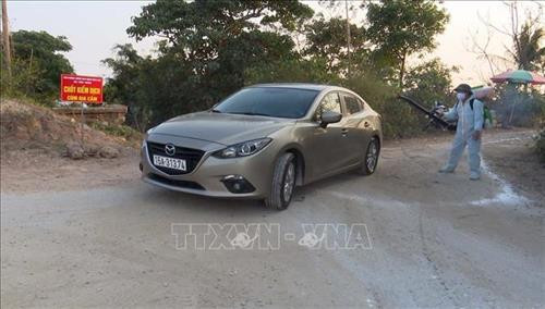 Chốt kiểm dịch phun khử trùng phương tiện từ vùng dịch đi ra. Ảnh: Trần Hoàng Ngọc - TTXVN