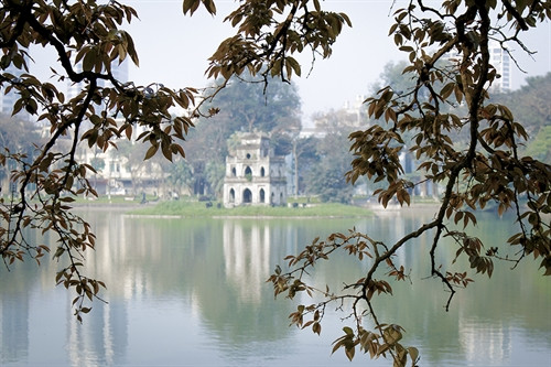Hồ Gươm và Tháp Rùa trầm lắng, yên bình hơn sau những tán lá bằng lăng mới nở. Hồ Gươm và Tháp Rùa trầm lắng, yên bình hơn sau những tán lá bằng lăng mới nở.