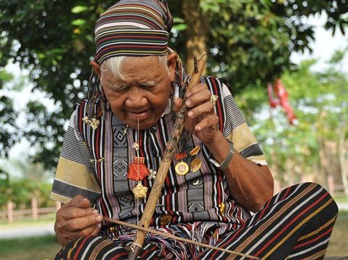 Nghệ nhân ưu tú Phạm Văn Sự với cây đàn B'rooc của dân tộc H'rê. Ảnh: Phạm Tiệp
