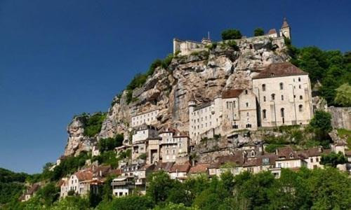 Ngôi làng cổ Rocamadour được xây dựng trên vách núi ở vùng Occitanie, miền tây nam Pháp. Từ thời Trung cổ, ngôi làng đã thu hút những người hành hương từ khắp châu Âu tới đây tham quan các công trình lịch sử và nhà thờ Đức Mẹ Maria. Thánh St Amator đã sống và qua đời tại ngôi làng Rocamadour ngay sau khi ông rời khỏi Jerusalem. Truyền thuyết kể rằng sau khi thi thể thánh St Amator được phát hiện, một số phép màu đã xảy ra. Ngôi làng bắt đầu thu hút nhiều người hành hương và ủng hộ từ các nhà vua Pháp, giúp ngôi làng xây dựng các nơi thờ cúng. Một lý do khác khiến Rocamadour thu hút nhiều du khách là phong cảnh đẹp. Các công trình cổ được xây dựng trên vách núi nhìn xuống sông Alzou. Các tòa nhà trong làng có độ cao cách mặt đất phía dưới khoảng 120m. Trung tâm của ngôi làng là nhà thờ hành hương Notre Dame, được cải tạo lại từ công trình gốc được xây dựng từ năm 1479. Ngoài ra, Rocamadour còn có nhiều công trình cổ kính khác được xây dựng từ thời Trung cổ. Du khách tham quan dọc một con đường dốc tại ngôi làng cổ Rocamadour. Những ngôi nhà được xây dựng trên vách đá dựng đứng. Ngôi làng cổ Rocamadour được xây dựng trên vách núi ở vùng Occitanie, miền tây nam Pháp. Từ thời Trung cổ, ngôi làng đã thu hút những người hành hương từ khắp châu Âu tới đây tham quan các công trình lịch sử và nhà thờ Đức Mẹ Maria. Thánh St Amator đã sống và qua đời tại ngôi làng Rocamadour ngay sau khi ông rời khỏi Jerusalem. Truyền thuyết kể rằng sau khi thi thể thánh St Amator được phát hiện, một số phép màu đã xảy ra. Ngôi làng bắt đầu thu hút nhiều người hành hương và ủng hộ từ các nhà vua Pháp, giúp ngôi làng xây dựng các nơi thờ cúng. Một lý do khác khiến Rocamadour thu hút nhiều du khách là phong cảnh đẹp. Các công trình cổ được xây dựng trên vách núi nhìn xuống sông Alzou. Các tòa nhà trong làng có độ cao cách mặt đất phía dưới khoảng 120m. Trung tâm của ngôi làng là nhà thờ hành hương Notre Dame, được cải tạo lại từ công trình gốc được xây dựng từ năm 1479. Ngoài ra, Rocamadour còn có nhiều công trình cổ kính khác được xây dựng từ thời Trung cổ. Du khách tham quan dọc một con đường dốc tại ngôi làng cổ Rocamadour. Những ngôi nhà được xây dựng trên vách đá dựng đứng.