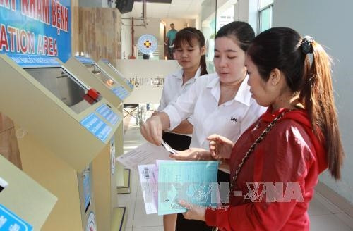 Nhân viên bệnh viện hướng dẫn bệnh nhân tại khu vực tự đăng ký và quẹt thẻ BHYT khám bệnh. Ảnh: Phương Vy-TTXVN Nhân viên bệnh viện hướng dẫn bệnh nhân tại khu vực tự đăng ký và quẹt thẻ BHYT khám bệnh. Ảnh: Phương Vy-TTXVN