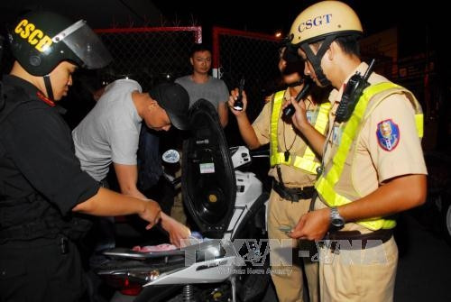 Cảnh sát giao thông và lực lượng chức năng kiểm tra bên trong cốp xe máy của chủ phương tiện trên đường Âu Cơ, quận Tân Phú. Ảnh: Mạnh Linh-TTXVN