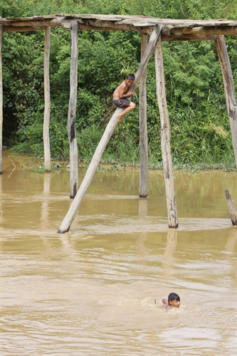 Trẻ em chơi trên cầu dân sinh và nhảy xuống tắm sông ở huyện Krông Bông (Đắk Lắk) tiềm ẩn nhiều nguy cơ tai nạn đuối nước.