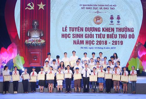 Giám đốc Sở Giáo dục và Đào tạo Hà Nội Chử Xuân Dũng tặng giấy khen cho các em học sinh tiêu biểu của các cấp học. Ảnh: Thanh Tùng- TTXVN