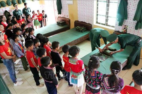 Cán bộ Đồn Biên phòng Pa Tần giới thiệu với học sinh Trường Tiểu học Pa Tần (Lai Châu) cách gấp chăn màn gọn gàng của chiến sĩ. Ảnh: Công Tuyên – TTXVN Cán bộ Đồn Biên phòng Pa Tần giới thiệu với học sinh Trường Tiểu học Pa Tần (Lai Châu) cách gấp chăn màn gọn gàng của chiến sĩ. Ảnh: Công Tuyên – TTXVN
