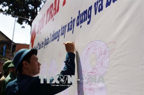 Thanh niên trúng tuyển nghĩa vụ quân sự ký cam kết chung tay xây dựng và bảo vệ Tổ quốc tại hội trại tòng quân. Ảnh: Thanh Vũ -TTXVN