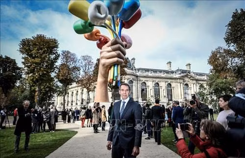 Nghệ sĩ người Mỹ Jeff Koons bên tác phẩm điêu khắc "Bó hoa tulip" tại Paris, Pháp. Ảnh: AFP/TTXVN