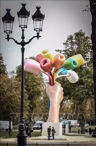 Tác phẩm điêu khắc "Bó hoa tulip" trưng bày tại Paris, Pháp. Ảnh: AFP/TTXVN Nghệ sĩ người Mỹ Jeff Koons (thứ 3 trái) chụp ảnhvới các đại biểu bên tác phẩm điêu khắc "Bó hoa tulip" tại Paris, Pháp . Ảnh: AFP/TTXVN