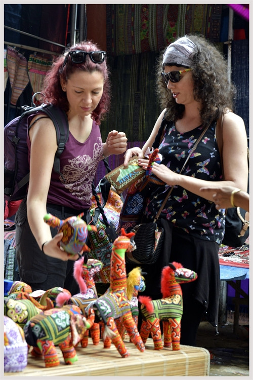 Du khách nước ngoài chọn mua đồ lưu niệm tại chợ phiên Bắc Hà