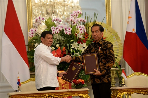 Tổng thống Indonesia Joko Widodo (phải) và Tổng thống Philippines Rodrigo Duterte (trái) trao đổi văn kiện sau lễ ký các hiệp định hợp tác song phương tại Jakarta. THX/TTXVN
