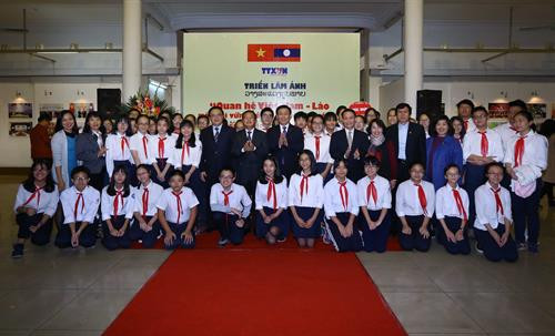 Các đại biểu chụp ảnh chung với học sinh trường THCS Trưng Vương (Hà Nội) tới tham quan triển lãm. Ảnh: Quang Quyết-TTXVN