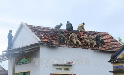 Bộ đội Biên phòng lợp lại mái nhà cho người dân. Ảnh: Phước Ngọc - TTXVN Bộ đội Biên phòng lợp lại mái nhà cho người dân. Ảnh: Phước Ngọc - TTXVN