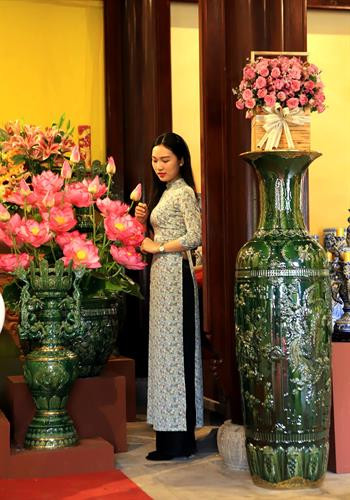 Khách tham quan chụp ảnh lưu niệm với những bình gốm sứ Bát Tràng được trưng bày ở vườn Thiệu Phương - Đại Nội Huế. Ảnh: Hoàng Hùng -TTXVN