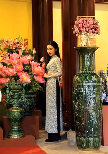 Khách tham quan chụp ảnh lưu niệm với những bình gốm sứ Bát Tràng được trưng bày ở vườn Thiệu Phương - Đại Nội Huế. Ảnh: Hoàng Hùng -TTXVN