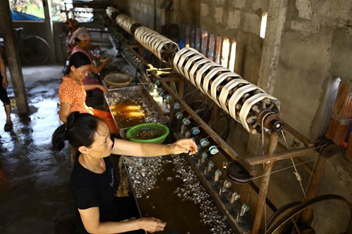 Người phụ nữ thôn Từ Đại (xã Chuyên Ngoại, Duy Tiên) miệt mài kéo tơ .