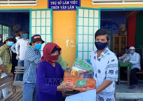 UBND xã Phước Nam cấp phát nhu yếu phẩm cho người dân có hoàn cảnh khó khăn ở các thôn lân cận . Ảnh: Công Thử - TTXVN