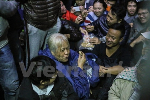 Bà Nguyễn Thị Xá cho biết, con bà ở Nhật Bản chưa kịp về Việt Nam nên bà thay con xếp hàng từ nửa đêm. (Ảnh: Minh Sơn/Vietnam+)