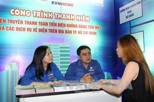 Đoàn thanh niên EVN HCMC hướng dẫn khách hàng thanh toán tiền điện không dùng tiền mặt và các dịch vụ về điện. Ảnh: Thanh Vũ-TTXVN