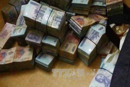 Tang vật tiền được thu giữ. Ảnh: Tuấn Anh-TTXVN