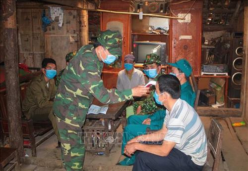 Cán bộ, chiến sỹ Đồn Biên phòng Tổng Cọt đo thân nhiệt cho người dân. Ảnh: Chu Hiệu - TTXVN