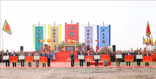 Tặng cờ thi đua và bằng công nhận của UBND tỉnh Hà Nam cho các xã có thành tích xuất sắc trong xây dựng nông thôn mới. Ảnh: Thanh Tùng-TTXVN