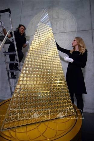 Nhân viên hãng Pro Aurum ghép các đồng xu vàng để tạo thành cây thông Giáng sinh tại Munich, Đức. Ảnh: Reuters/ TTXVN