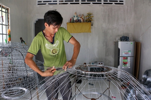 Gia đình anh Nguyễn Văn Cường, ấp Long Huê, xã Long Thới, thoát nghèo nhờ nghề đan bội kẽm. Ảnh : Trần Thị Thu Hiền – TTXVN