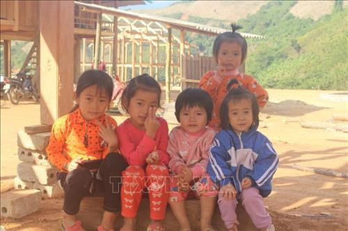 Những chủ nhân tương lai của bản Poọng tại khu tái định cư mới. Ảnh: Hoa Mai – TTXVN Những chủ nhân tương lai của bản Poọng tại khu tái định cư mới. Ảnh: Hoa Mai – TTXVN
