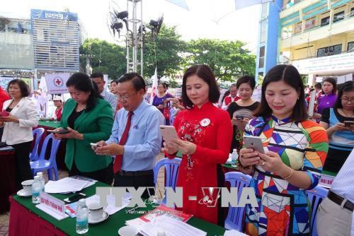 Các đại biểu nhắn tin ủng hộ chương trình “Chung sức vì biển đảo quê hương” tại buổi lễ. Ảnh: Thế Anh-TTXVN