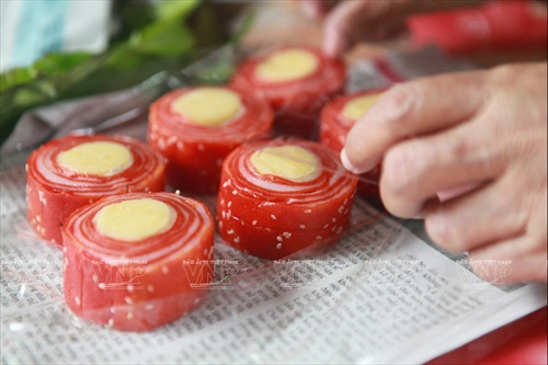 Bánh có màu đỏ tươi của gấc, vàng của nhân đỗ xanh và điểm trắng của vừng.