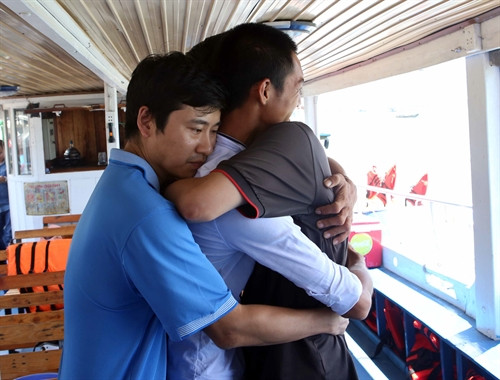 Hành khách trong vụ lật tàu được anh Mai Viết Dụng (áo trắng) cứu vui mừng gặp lại ân nhân (ảnh chụp tại cầu cảng sông Hàn ngày 6/6). Ảnh: Trần Lê Lâm- TTXVN