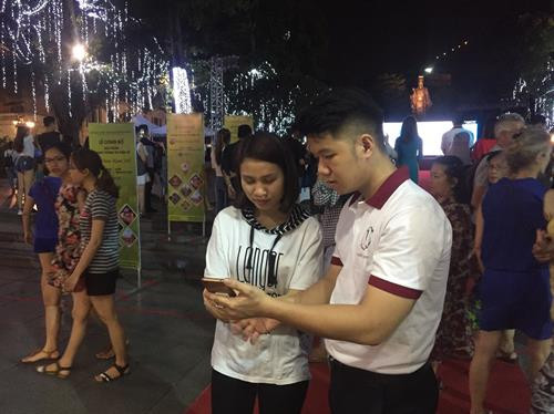 Cài đặt miễn phí ứng dụng cho du khách. Ảnh: Đinh Thuận - TTXVN