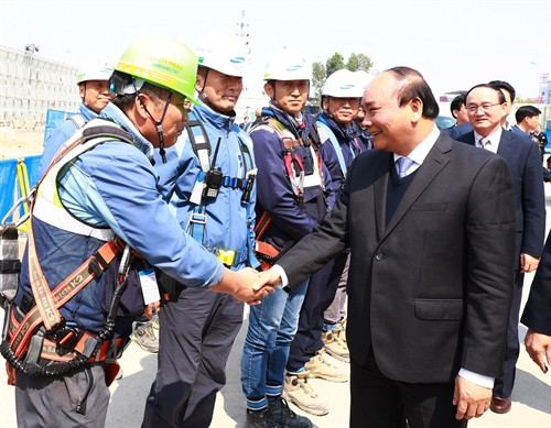 Sáng 12/2/2017, tại tỉnh Bắc Ninh, Thủ tướng Nguyễn Xuân Phúc đến thăm Tập đoàn Samsung Display Việt Nam. Trong ảnh: Thủ tướng Nguyễn Xuân Phúc với công nhân đang thi công nhà máy số 3 Tập đoàn Samsung Display Việt Nam. Ảnh: Thống Nhất-TTXVN