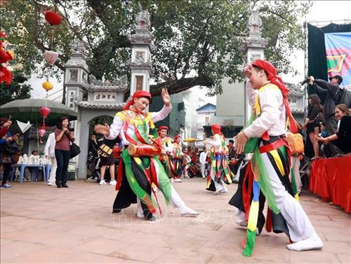 Điệu múa cổ "Con đĩ đánh bồng" do các chàng trai trong làng Triều Khúc giả gái thực hiện. Ảnh: Hoàng Hùng - TTXVN