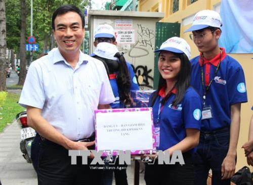 Đại diện Ban Giám hiệu trường đại học Khoa học xã hội và Nhân văn, Đại học Quốc gia Thành phố Hồ Chí Minh tặng quà cho sinh viên tình nguyện của trường. Ảnh: Xuân Dự - TTXVN