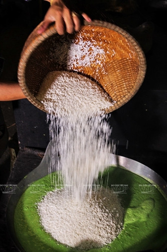 Gạo nếp được đổ vào nước cốt lá dứa để xào.