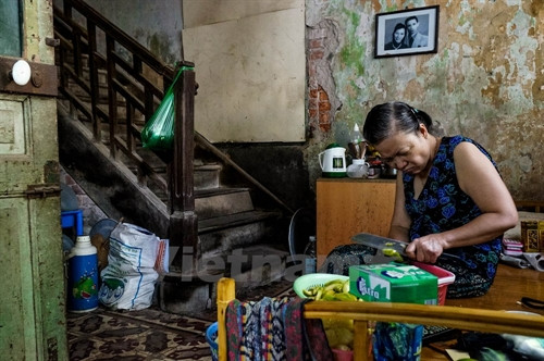 Bà cho biết bà cùng 6 hộ dân nơi đây luôn phải sống trong tình trạng ẩm thấp, khó chịu, mọi sinh hoạt tắm giặt, vệ sinh đều phải chung nhau. (Ảnh: Minh Sơn/Vietnam+)