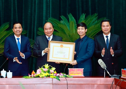 Chiều 12/2/2017, tại thành phố Bắc Ninh, tỉnh Bắc Ninh, Thủ tướng Nguyễn Xuân Phúc làm việc với lãnh đạo tỉnh Bắc Ninh. Trong ảnh: Thủ tướng Nguyễn Xuân Phúc trao Bằng công nhận đạt chuẩn Nông thôn mới năm 2016 cho huyện Tiên Du, tỉnh Bắc Ninh. Ảnh: Thống Nhất-TTXVN