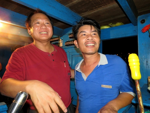 Bộ trưởng Bộ Thông tin và Truyền thông Trương Minh Tuấn (trái) vào tận cabin chúc mừng chủ tàu Nguyễn Nhật Linh có hải sản được cấp giấy chứng thực nguồn gốc. Ảnh: Mạnh Thành- TTXVN