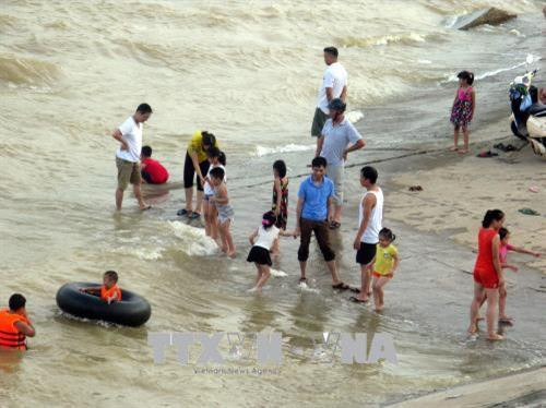 Người dân tắm sông khi Thủy điện Hòa Bình xả Lũ. Ảnh: Thanh Hải - TTXVN