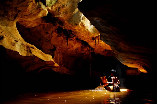 Các em nhỏ người địa phương bắt cá ở mạch nước ngầm chảy trong hang